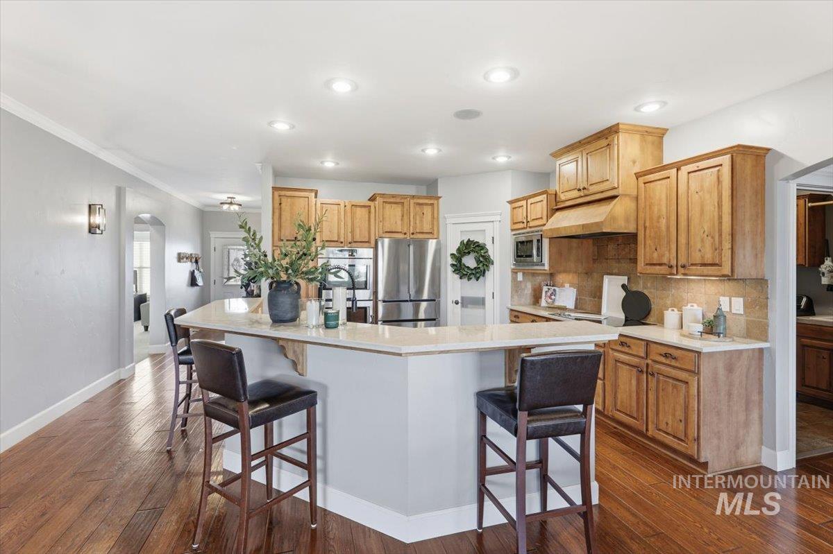 8982 New Castle Drive Middleton, ID 83644 - Photo 11 of 48 Kitchen featuring a kitchen breakfast bar, arched walkways, appliances with stainless steel finishes, a spacious island, and recessed lighting
