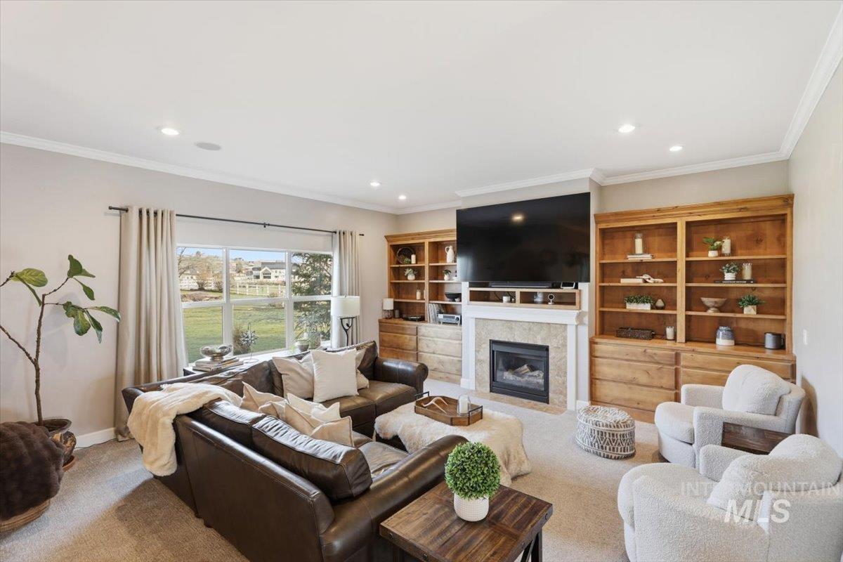 8982 New Castle Drive Middleton, ID 83644 - Photo 18 of 48 Carpeted living room featuring a fireplace with flush hearth, ornamental molding, and recessed lighting