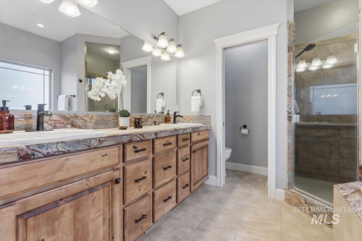 8982 New Castle Drive Middleton, ID 83644 - Photo 23 of 48 Full bath featuring double vanity, light tile patterned floors, and a stall shower