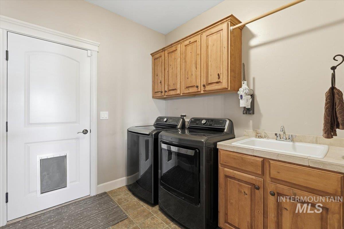 8982 New Castle Drive Middleton, ID 83644 - Photo 26 of 48 Washroom with cabinet space, washer and clothes dryer, and light tile patterned floors