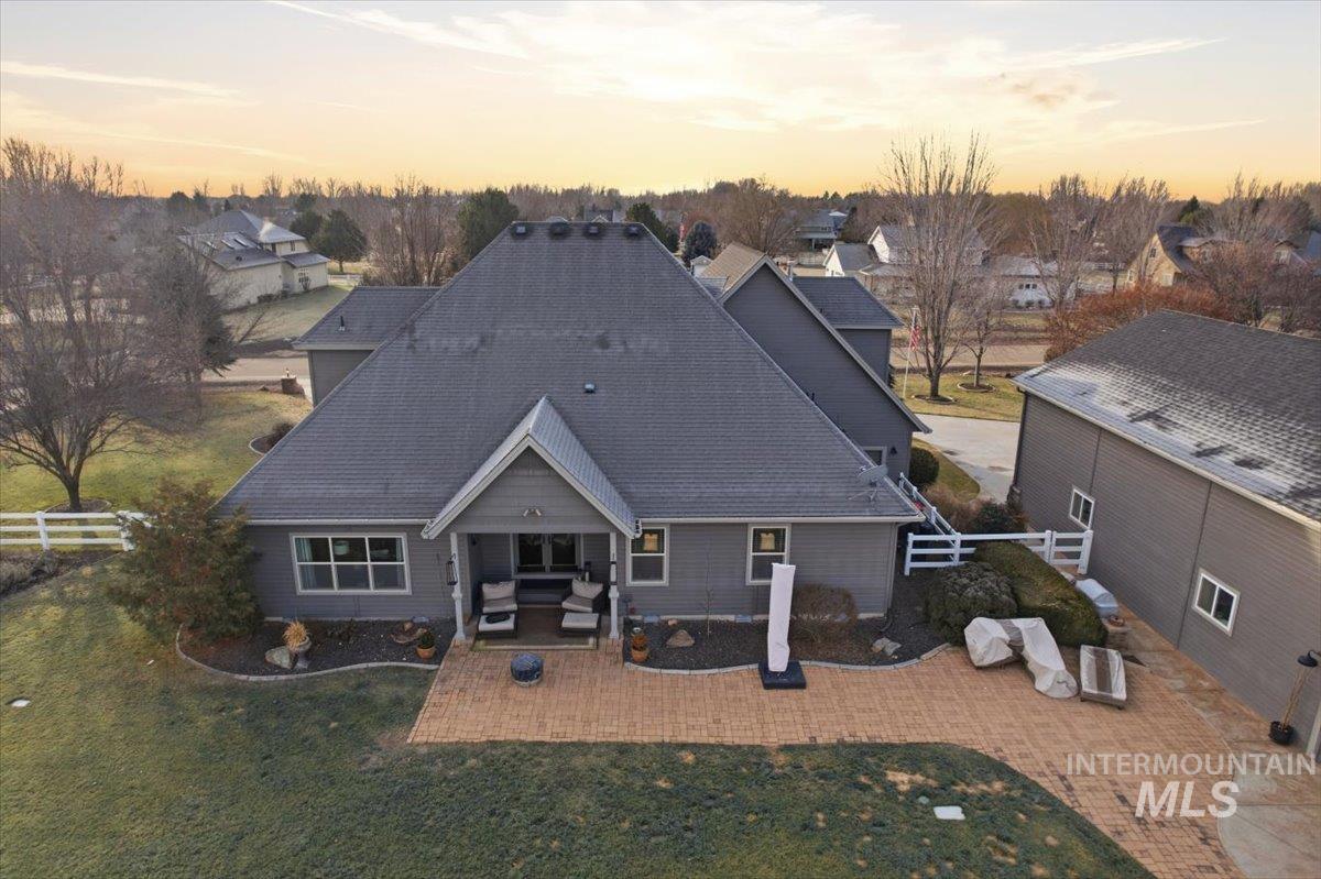8982 New Castle Drive Middleton, ID 83644 - Photo 32 of 48 Back of house at dusk featuring a patio area and roof with shingles