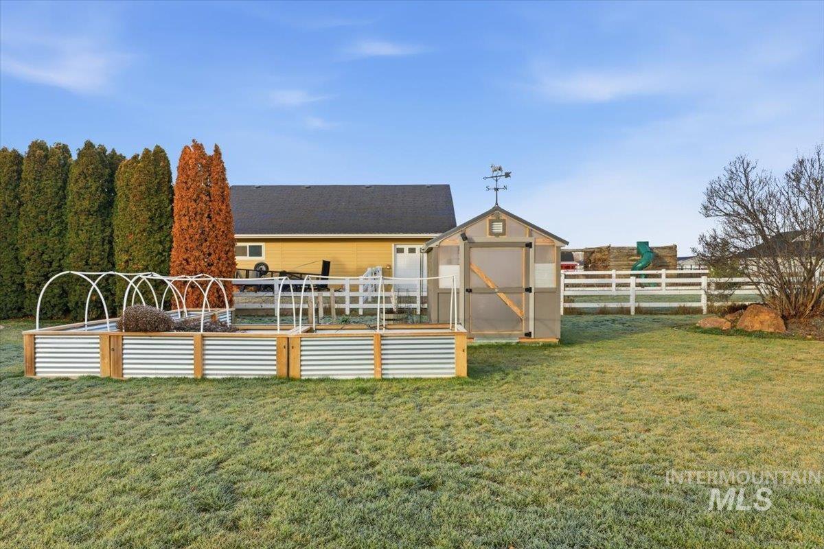 8982 New Castle Drive Middleton, ID 83644 - Photo 40 of 48 Back of property featuring a fenced backyard, a storage shed, and a garden