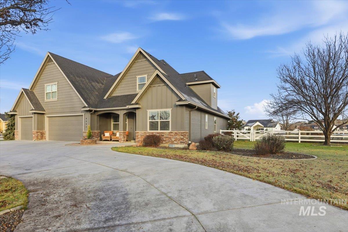 8982 New Castle Drive Middleton, ID 83644 - Photo 42 of 48 Craftsman-style house with stone siding, board and batten siding, driveway, a porch, and a garage