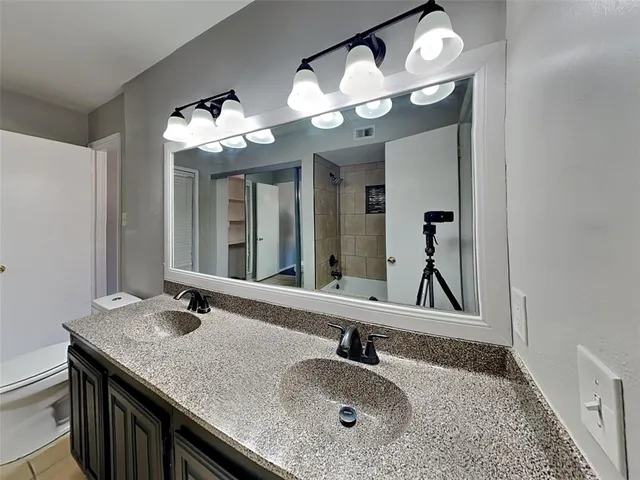 a bathroom with a granite countertop sink and a mirror