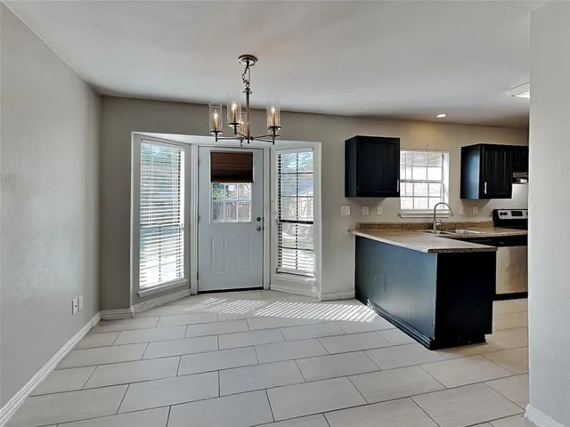 a view of kitchen with granite countertop cabinets and refrigerator