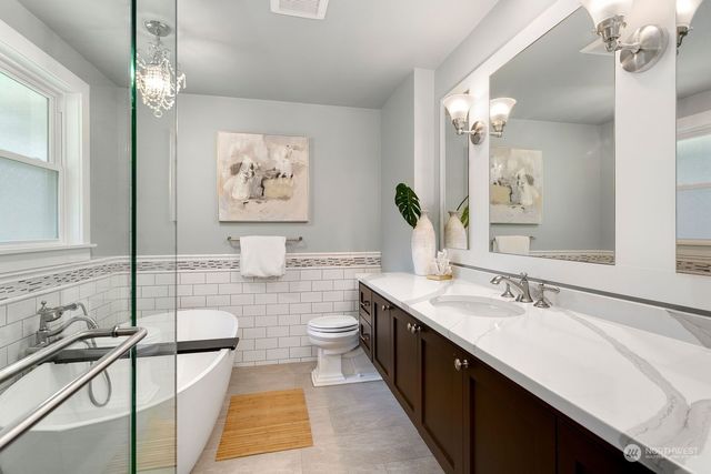 a bathroom with a double vanity sink a mirror and a bathtub