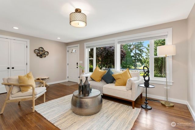 a living room with furniture large window and a table