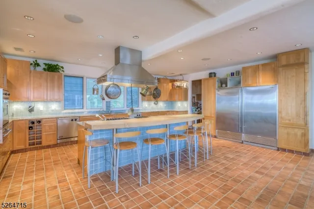a kitchen with stainless steel appliances granite countertop a sink and a refrigerator