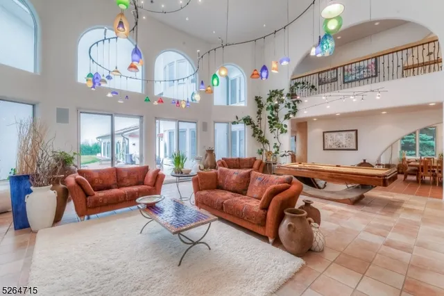 a living room with furniture a chandelier and a pool table
