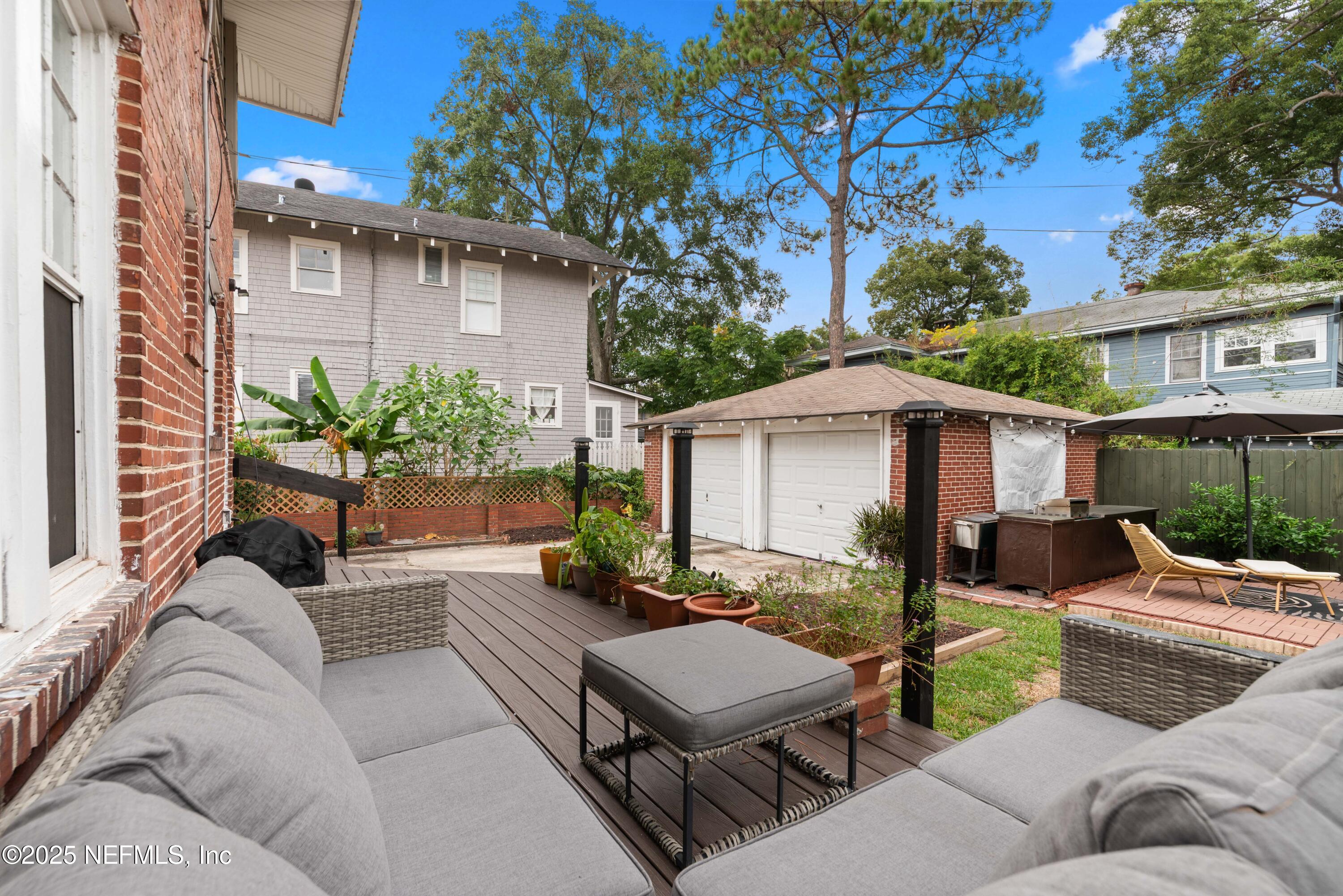 3023 Oak Street Jacksonville, FL 32205 - Photo 41 of 50 a view of a patio with couches and a table and chairs under an umbrella with a fire pit