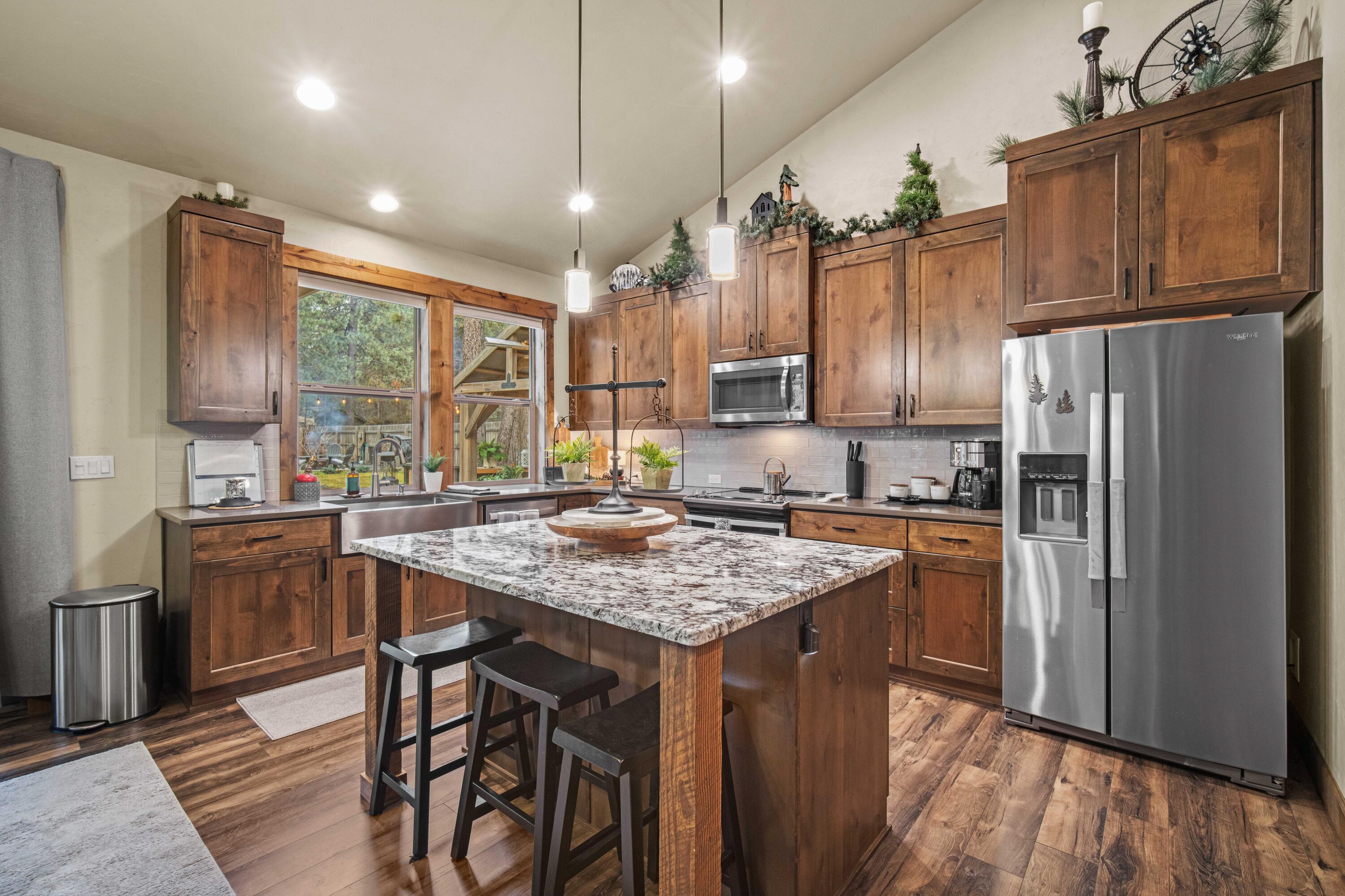 16927 Covina Road Bend, OR 97707 - Photo 10 of 54 Kitchen in Three Rivers South home featuring a large island, rich cabinetry, and windows overlooking the peaceful backyard setting.