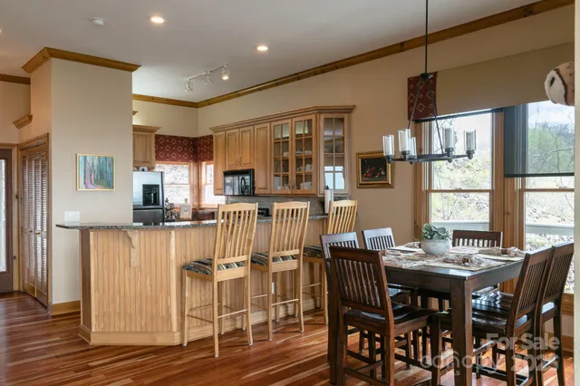 a kitchen with stainless steel appliances kitchen island granite countertop a table chairs and a refrigerator