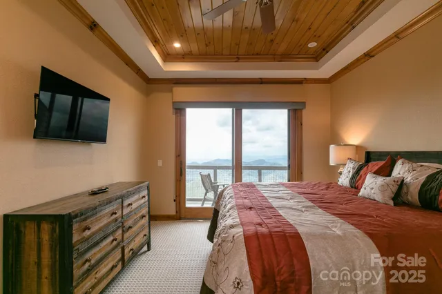 a bedroom with a bed and a flat tv screen on dresser