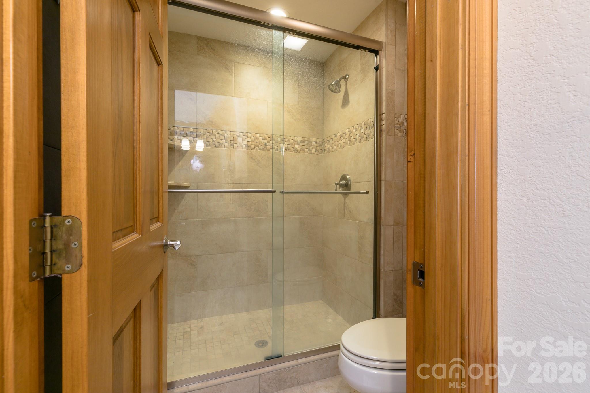 140 Slickrock Road, Unit F3 Burnsville, NC 28714 - Photo 22 of 31 a bathroom with a shower and a toilet