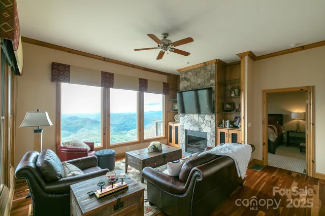 a living room with furniture fireplace and large windows