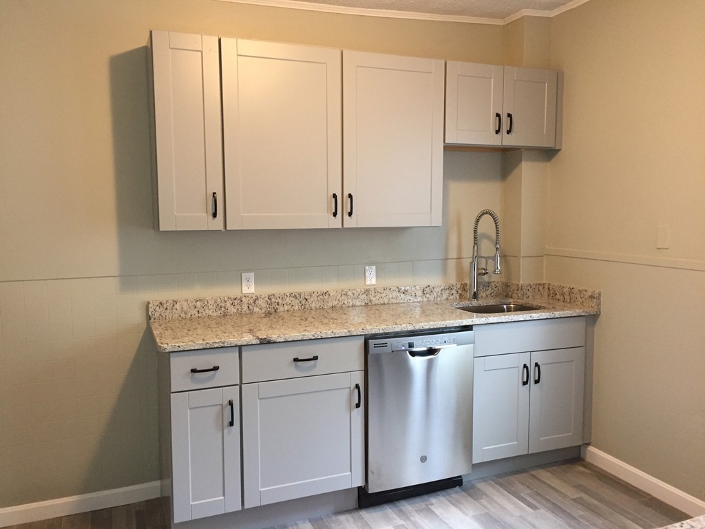 a kitchen with granite countertop a sink and cabinets