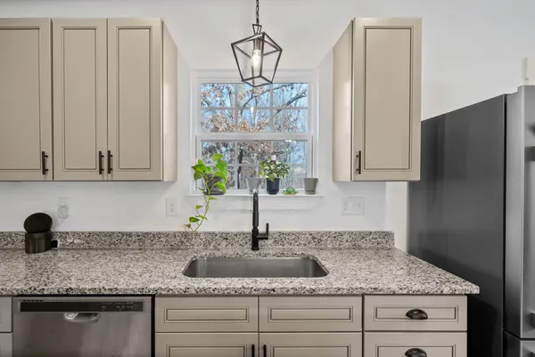 a large kitchen with kitchen island a large counter top space a sink stainless steel appliances and cabinets