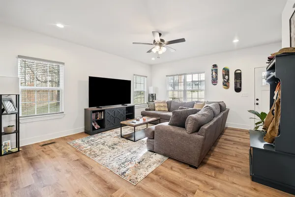 a living room with furniture and a flat screen tv with kitchen view