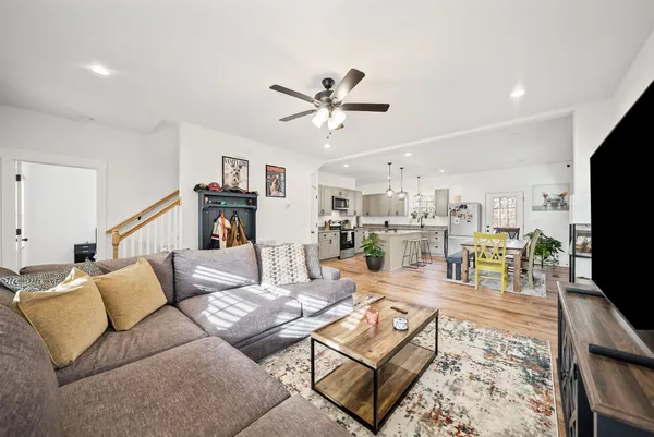 a kitchen with stainless steel appliances granite countertop a dining table chairs and view living room