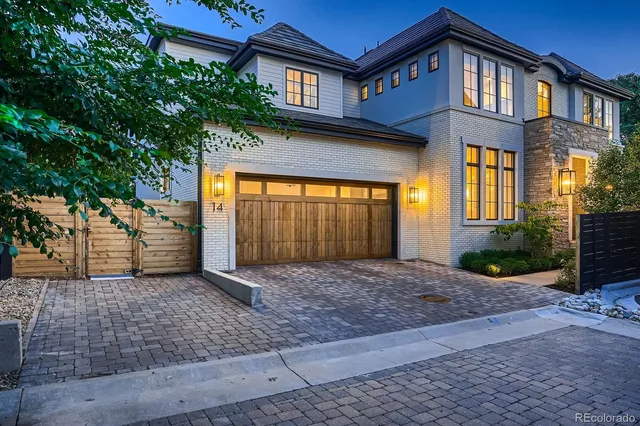 a view of a brick house with large windows and a small yard