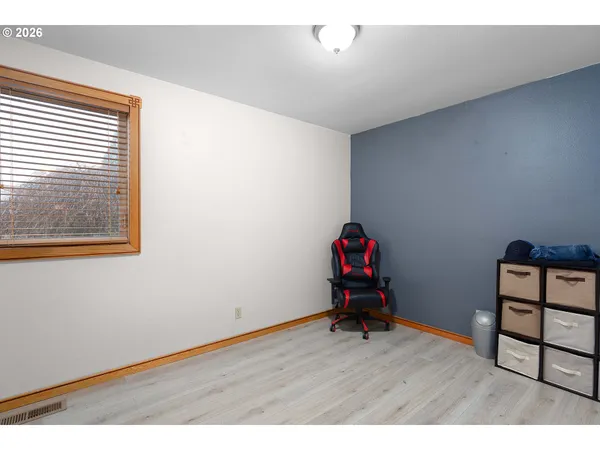 a view of an empty room with wooden floor and closet