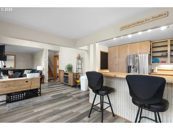 a kitchen with stainless steel appliances wooden floor and chairs