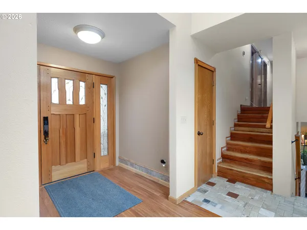 a view of a hallway with wooden floor and a window