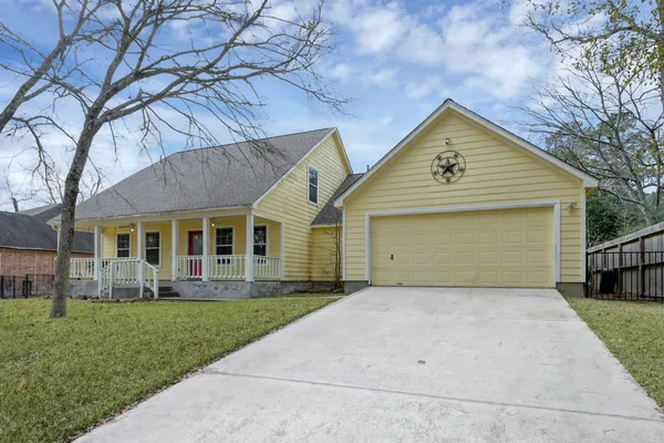 front view of a house with a yard and an trees