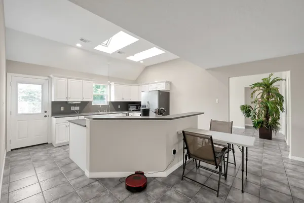 a kitchen with granite countertop white cabinets white appliances and sink