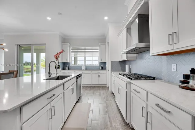 a kitchen with granite countertop a sink a counter space appliances and cabinets