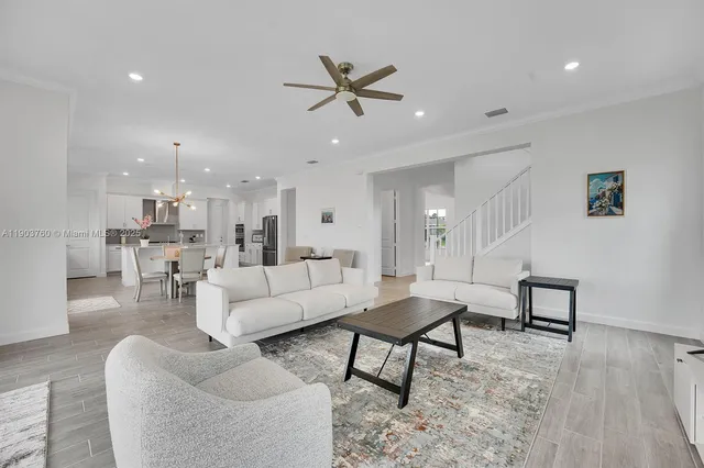 a living room with furniture and a view of kitchen