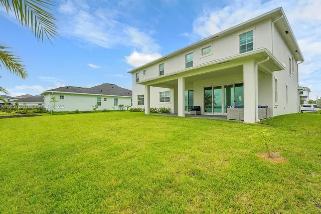a view of a house with a big yard and potted plants