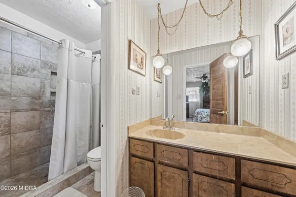 a bathroom with a sink a toilet and shower