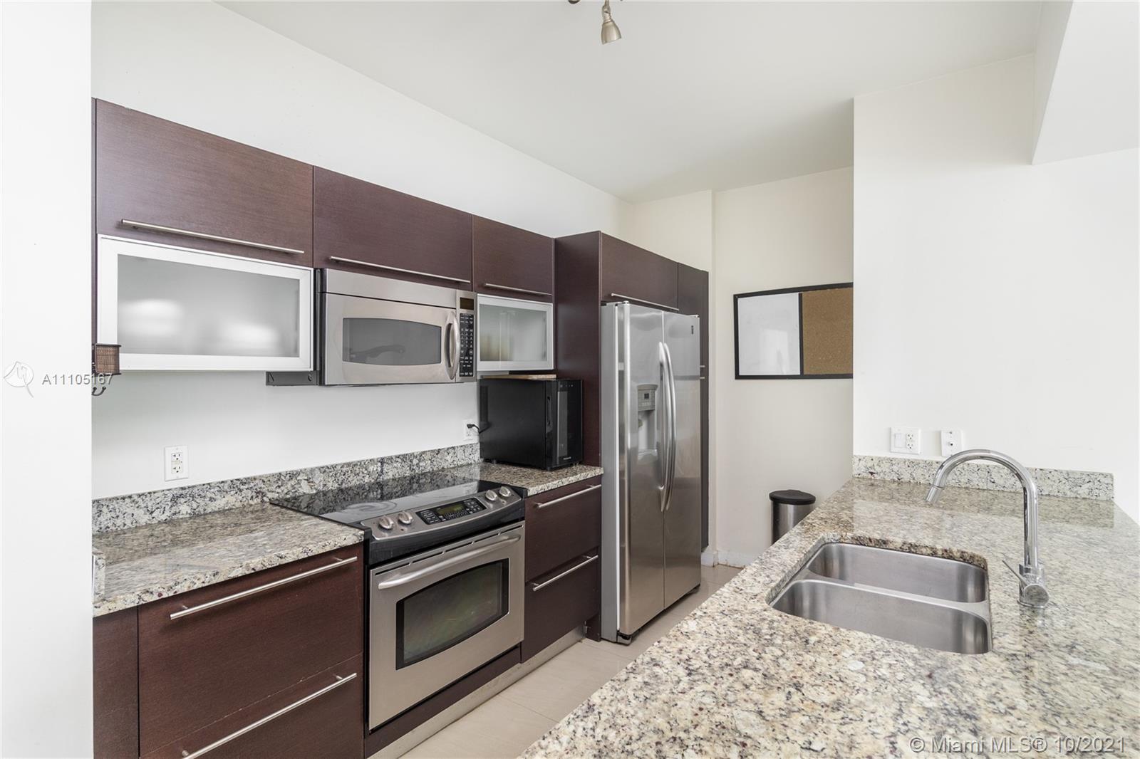 951 Brickell Avenue, Unit 2706 Miami, FL 33131 - Photo 11 of 35 a kitchen with stainless steel appliances granite countertop a sink stove and refrigerator