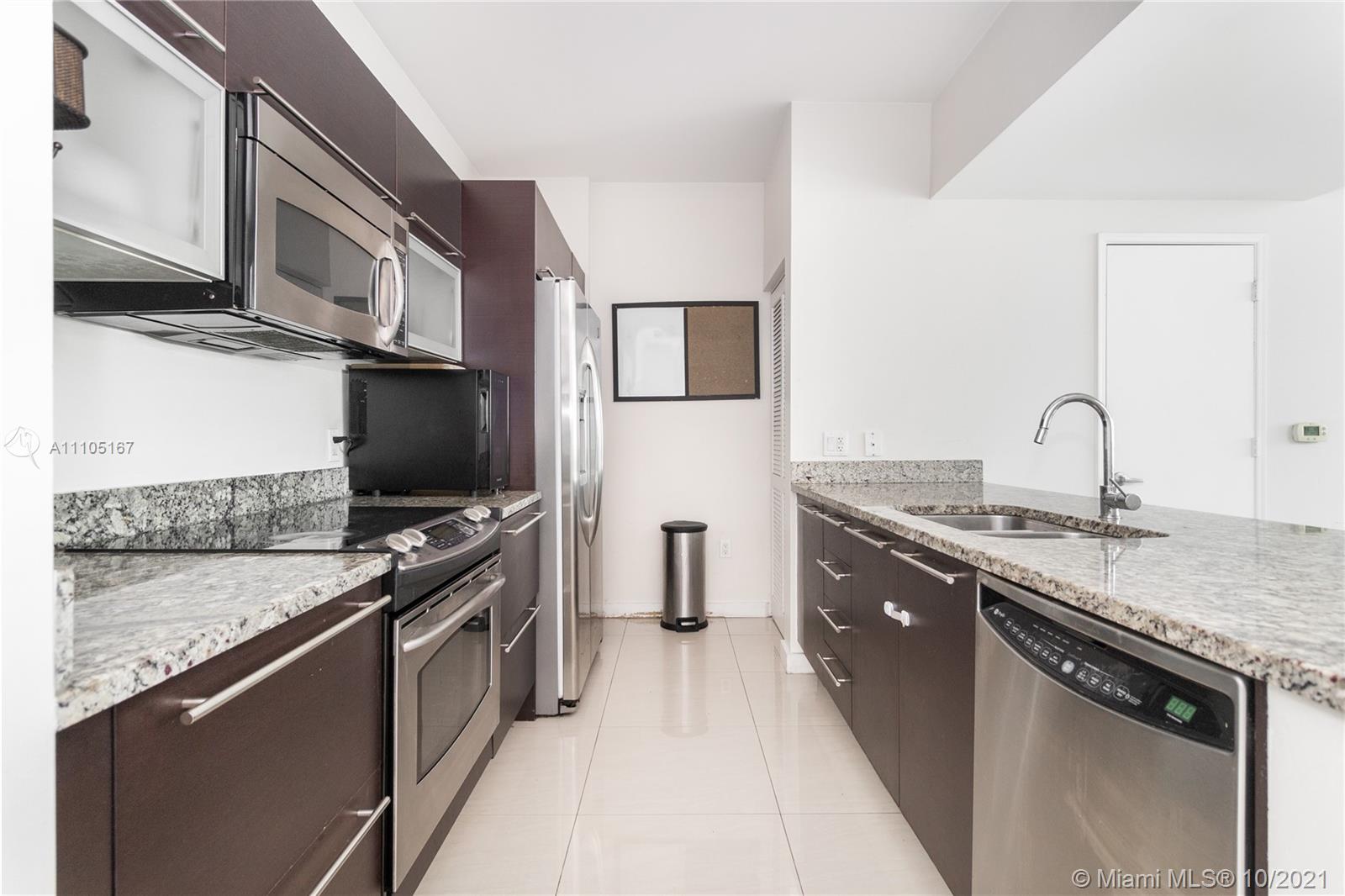 951 Brickell Avenue, Unit 2706 Miami, FL 33131 - Photo 12 of 35 a kitchen with stainless steel appliances granite countertop a sink and a stove