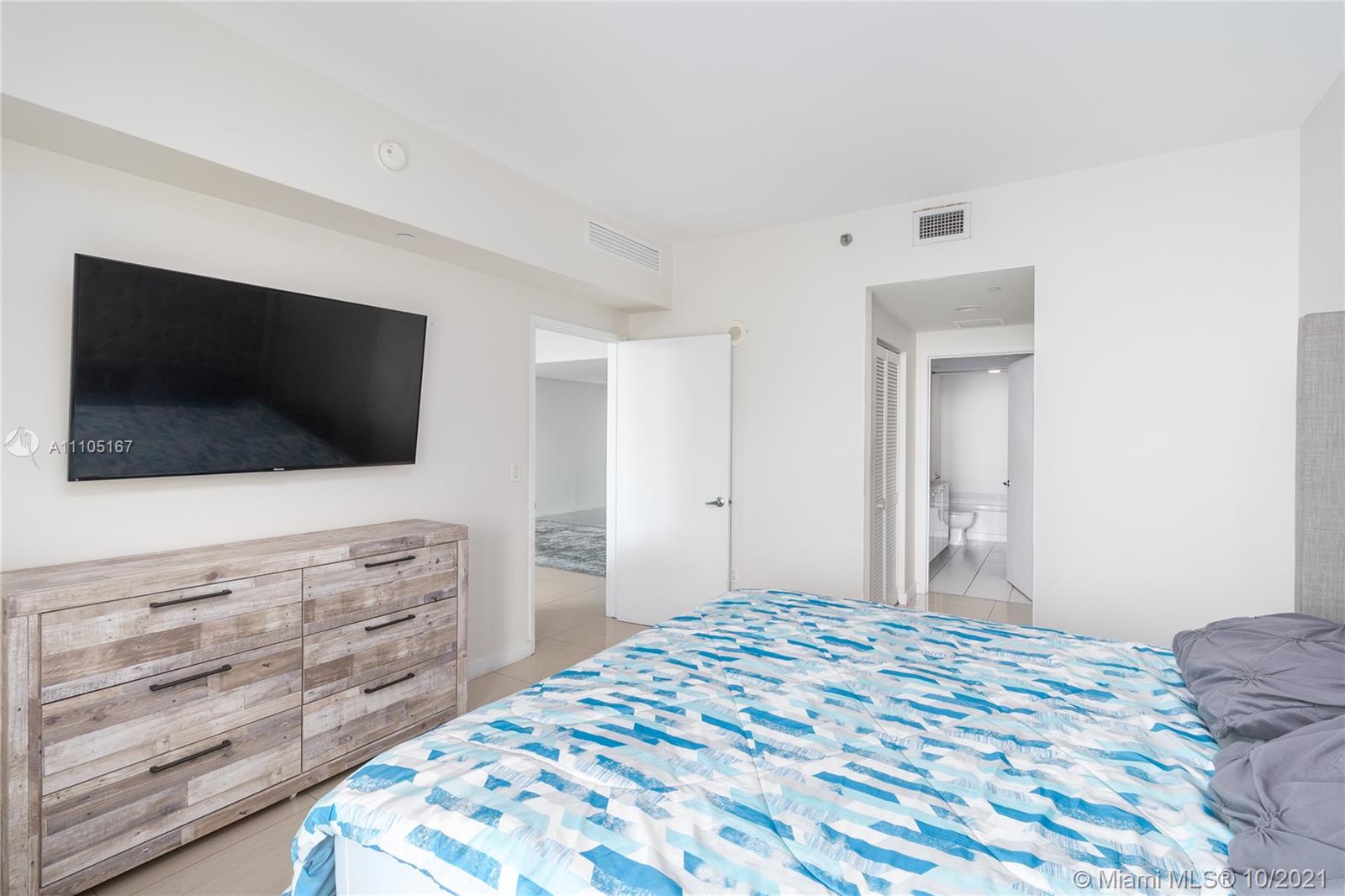951 Brickell Avenue, Unit 2706 Miami, FL 33131 - Photo 16 of 35 a bedroom with a bed and a flat screen tv in it