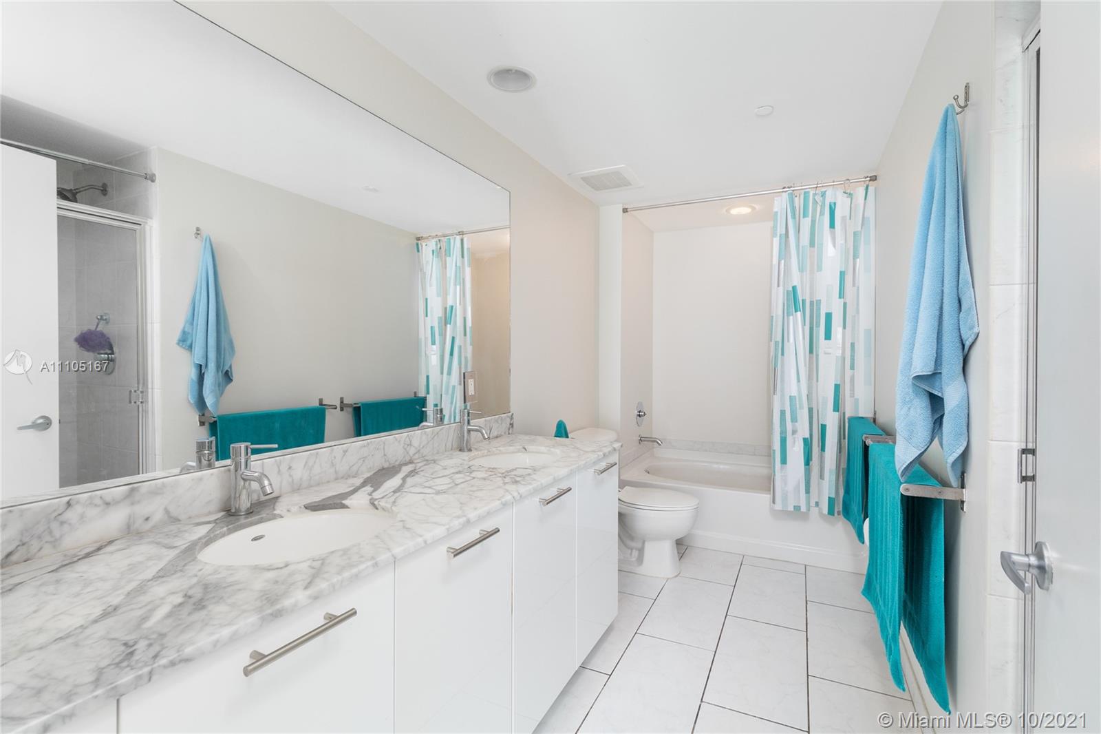 951 Brickell Avenue, Unit 2706 Miami, FL 33131 - Photo 18 of 35 a spacious bathroom with a double vanity sink and a mirror