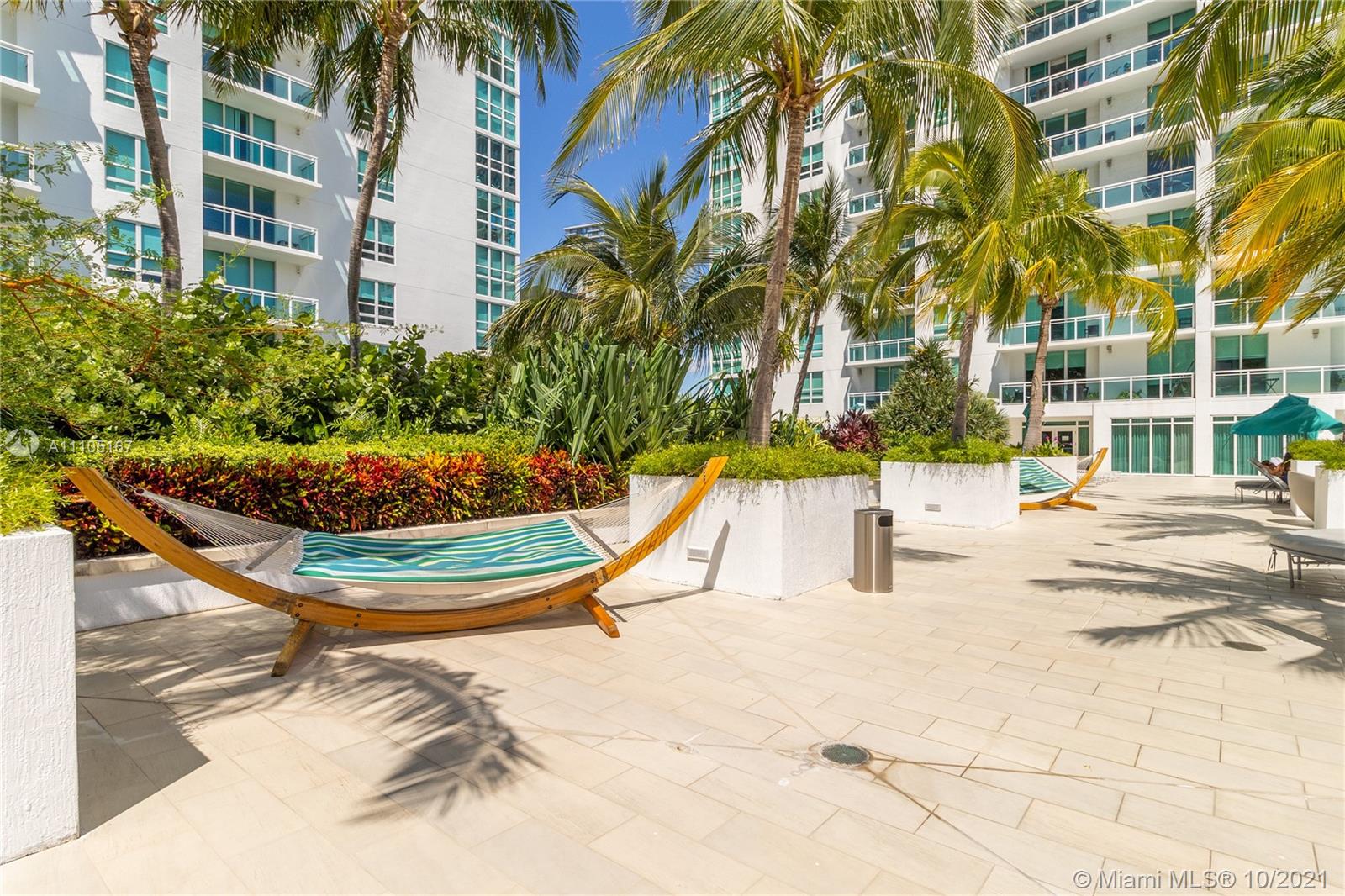 951 Brickell Avenue, Unit 2706 Miami, FL 33131 - Photo 27 of 35 a view of a swimming pool with a lawn chairs and palm trees