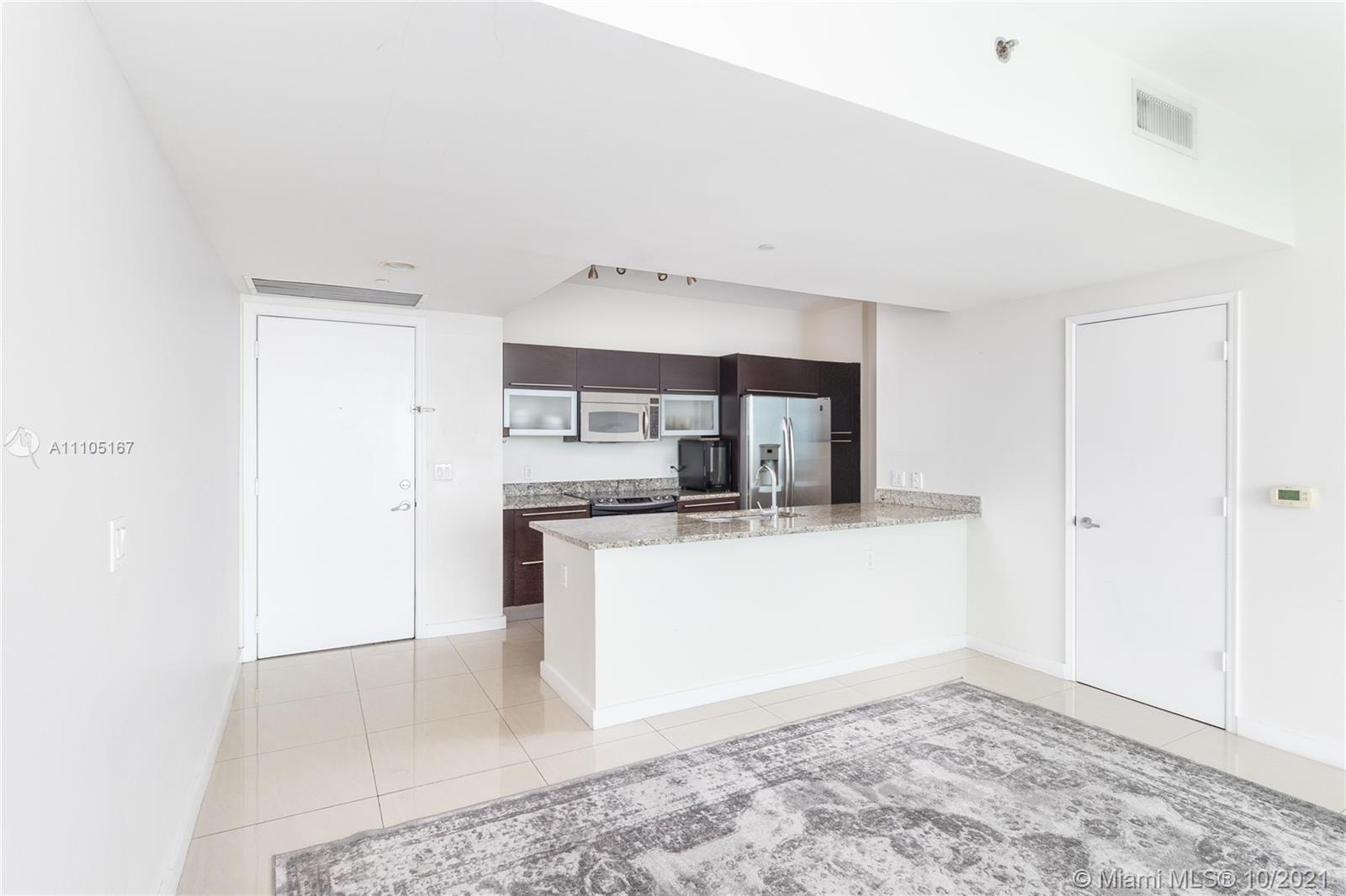 951 Brickell Avenue, Unit 2706 Miami, FL 33131 - Photo 10 of 35 a kitchen with stainless steel appliances a sink and a refrigerator