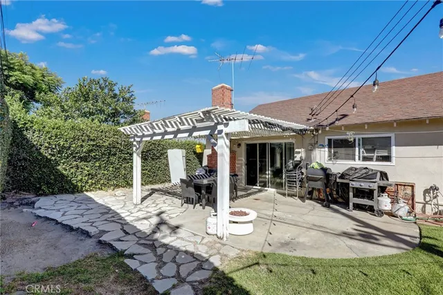 a patio with table and chairs and potted plants