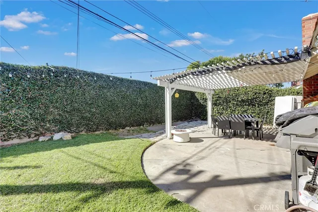 a view of a patio with a table and chairs and a barbeque