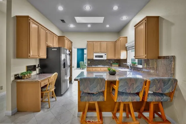 a kitchen with a table chairs refrigerator and a sink