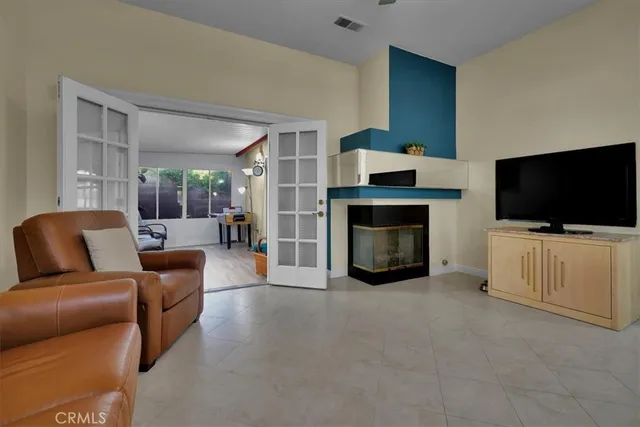 a living room with furniture a flat screen tv and a fireplace