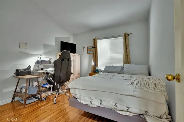 a bedroom with a bed and wooden floor