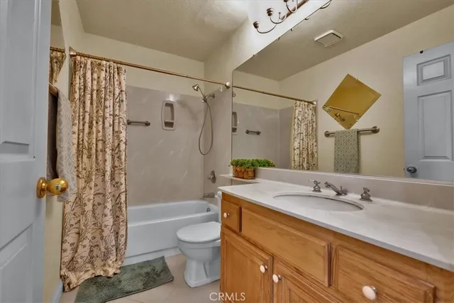 a bathroom with a granite countertop sink a toilet and shower