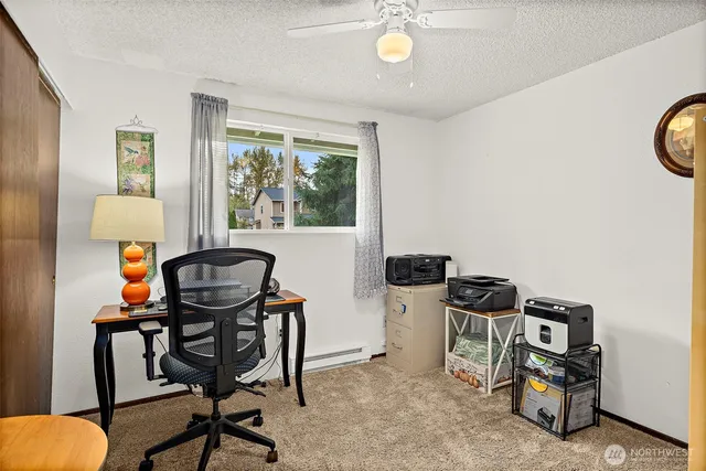 a view of a workspace with furniture and a window