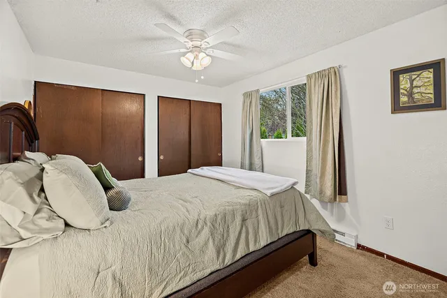 a bedroom with a bed lamp and a large window
