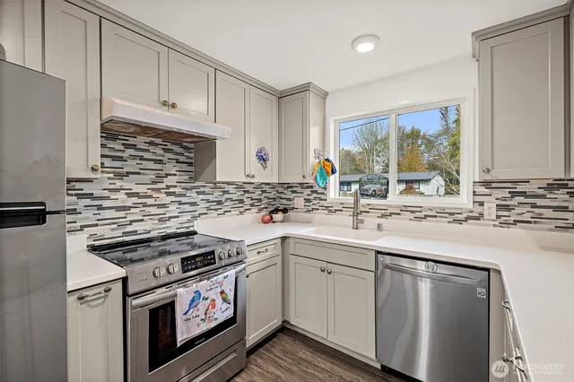 a kitchen with stainless steel appliances a sink stove and cabinets