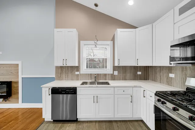a kitchen with granite countertop a sink a stove and cabinets