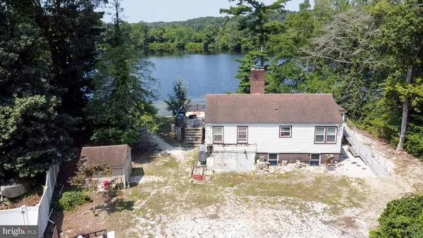 an aerial view of a house with lake view and a trees